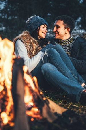 Couple camping by fireside